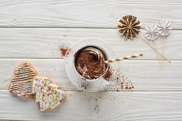 Draufsicht auf Weihnachtsplätzchen und Kakao im Becher mit Dekoration auf weißem Holztisch — Stockfoto