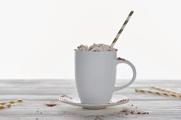 Christmas cacao with whipped cream and straw in mug on wooden table isolated on white — Stock Photo
