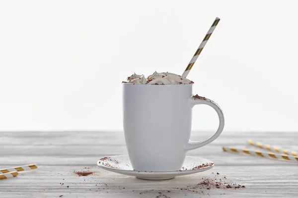 Weihnachtskakao mit Schlagsahne und Stroh im Becher auf Holztisch isoliert auf weiß — Stockfoto