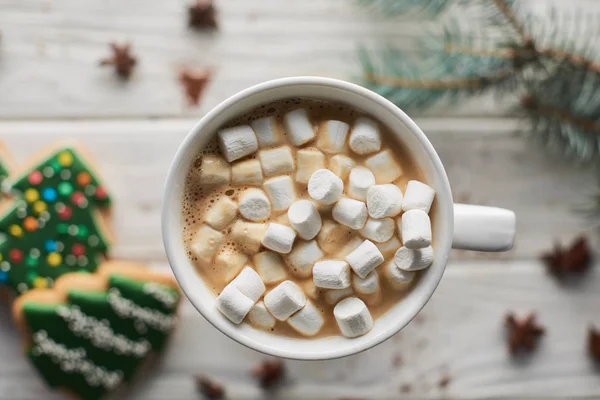 Foyer sélectif de cacao de Noël avec guimauve en tasse sur table en bois blanc avec branche de sapin et biscuits — Photo de stock