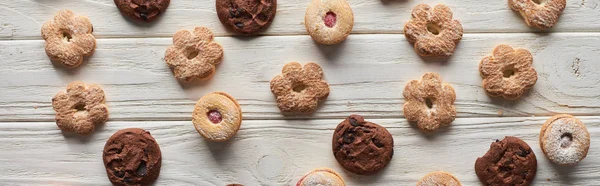 Top view of delicious sweet cookies on white wooden table, panoramic shot — Stock Photo