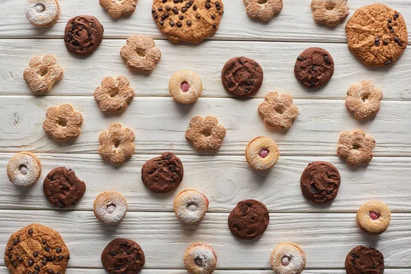 Vue du dessus de délicieux biscuits sucrés sur une table en bois blanc — Photo de stock
