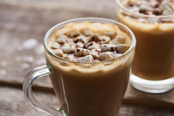 Cacao with marshmallow and cacao powder in mugs on wooden table — Stock Photo