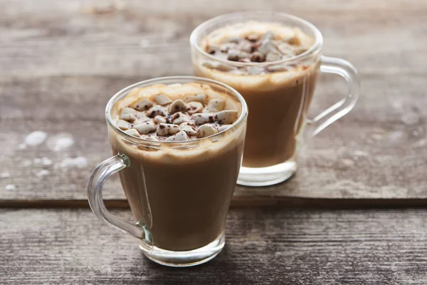 Cacao with marshmallow and cacao powder in mugs on wooden table — Stock Photo