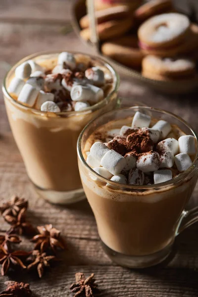 Selective focus of cacao with marshmallow in mugs on wooden table with anise — Stock Photo