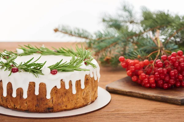 Torta di Natale con rosmarino e bacche di viburno su tavolo di legno con rami di abete rosso — Foto stock