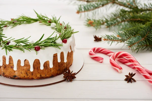 On white wooden table with candy canes and spruce branches — Stock Photo