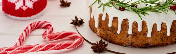 Різдвяний пиріг з глазур'ю на білому дерев'яному столі з чашкою, цукерками та ялиновими гілками — стокове фото