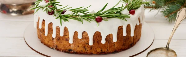 Tarte de Noël avec glaçage blanc, romarin et canneberges sur table en bois blanc — Photo de stock