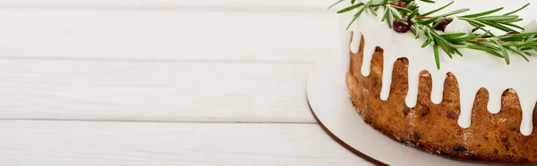 Torta natalizia festiva con glassa, rosmarino e mirtilli rossi su tavolo di legno bianco — Foto stock