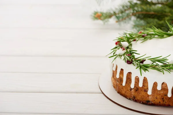 Weihnachtskuchen auf weißem Holztisch mit Fichtenzweigen — Stockfoto