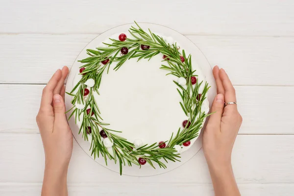 Cropped view of woman holding christmas pie with rosemary and cranberries — Stock Photo