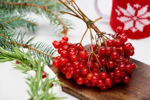 Bagas de viburnum e torta de Natal na mesa de madeira branca com ramos de abeto — Fotografia de Stock