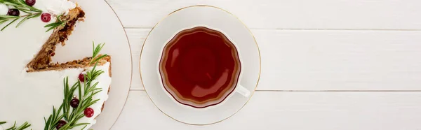 Top view of cup of tea and christmas pie with rosemary and cranberries on white wooden table — Stock Photo