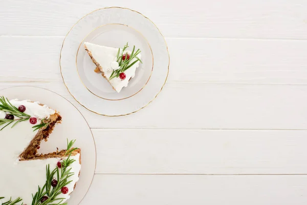 Top view of christmas pie with icing, rosemary and cranberries on white wooden table — Stock Photo