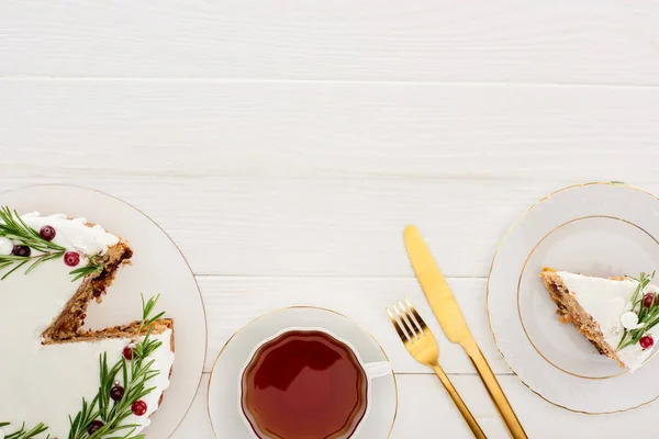 Vista dall'alto della torta di Natale con rosmarino e tazza di tè sul tavolo di legno bianco — Foto stock