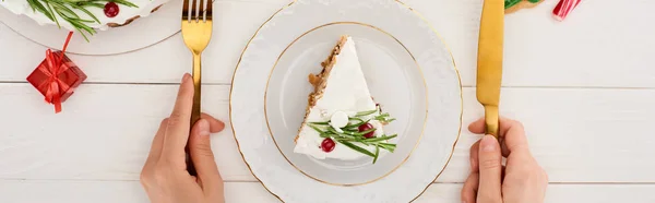 Vue recadrée de fille tenant fourchette et couteau pour manger tarte de Noël et biscuits sur table en bois blanc — Photo de stock