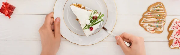 Vue recadrée de la femme avec morceau de tarte de Noël et biscuits sur table en bois blanc — Photo de stock