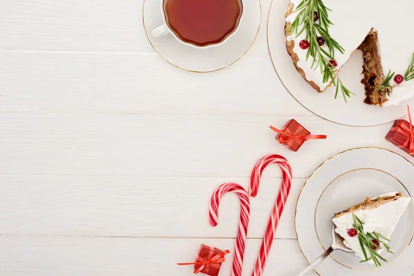 Vue du dessus de tarte de Noël sur table en bois blanc avec tasse de thé, cannes à bonbons et petits cadeaux — Photo de stock