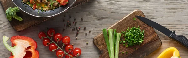 Vista superior de tortilla casera en sartén con ingredientes en mesa de madera - foto de stock