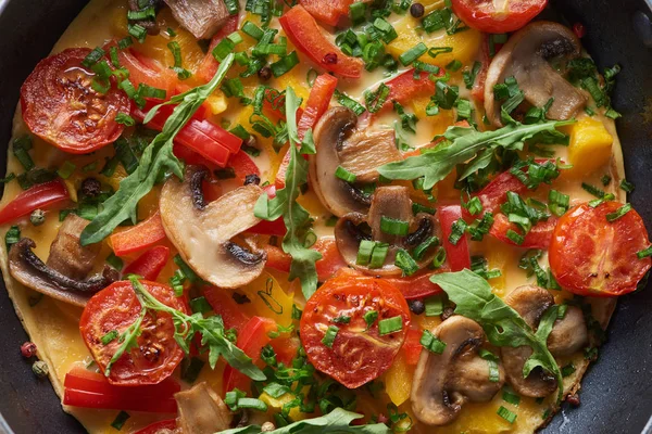 Top view of homemade omelet with mushrooms, tomatoes and greens — Stock Photo