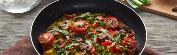 Frittata fatta in casa con verdure e verdure in padella su tavola di legno con ingredienti — Foto stock