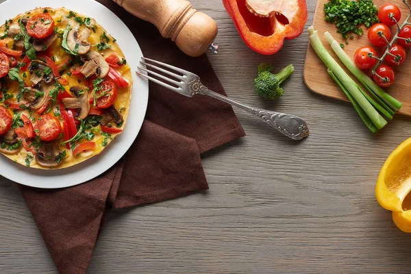 Vista superior de omelete caseiro para o café da manhã em mesa de madeira com ingredientes — Fotografia de Stock