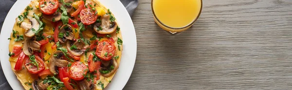 Blick von oben auf ein Glas Saft und hausgemachtes Omelett mit Gemüse zum Frühstück — Stockfoto