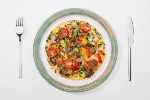 Top view of plate with tasty omelet with tomatoes and mushrooms for breakfast on white table — Stock Photo