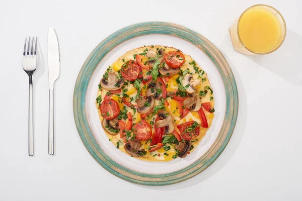Draufsicht auf leckeres Omelett zum Frühstück auf weißem Tisch mit Saft, Gabel und Messer — Stockfoto