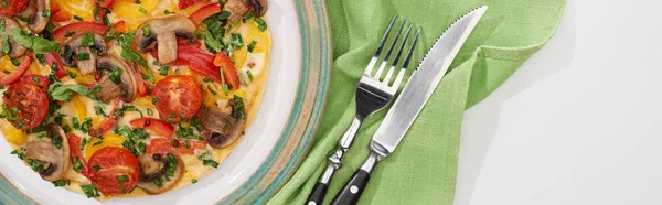 Top view of homemade omelet on plate with napkin, fork and knife — Stock Photo