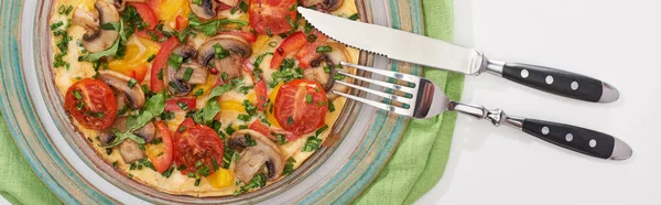 Teller mit leckerem Omelett zum Frühstück auf weißem Tisch mit Serviette, Gabel und Messer — Stockfoto