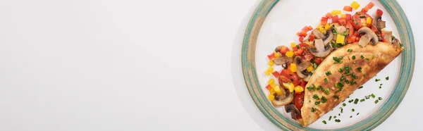 Vue du dessus de la plaque avec omelette enveloppée maison avec légumes sur table blanche — Photo de stock