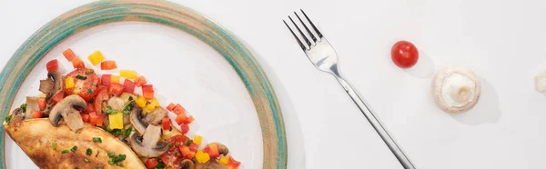 Vue du dessus de la plaque avec omelette enveloppée maison sur table blanche avec ingrédients et fourchette — Photo de stock