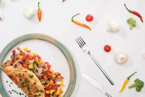 Top view of plate with homemade wrapped omelet with vegetables on white table with fresh ingredients — Stock Photo