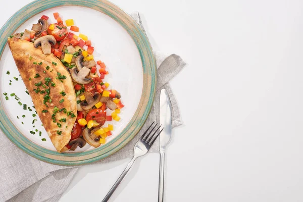 Teller mit leckerem Omelett mit Champignons und Paprika auf weißem Tisch mit Gabel und Messer — Stockfoto