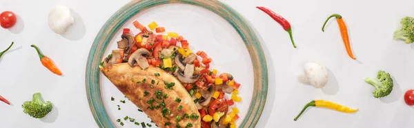 Vista dall'alto della deliziosa omelette avvolta con verdure sul piatto con ingredienti — Foto stock