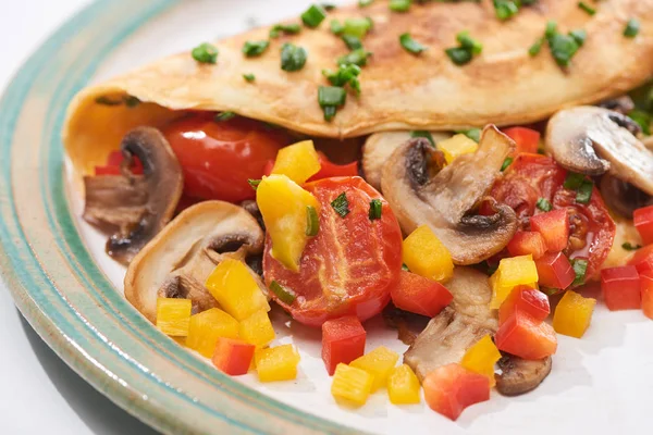 Крупный план домашнего омлета с овощами на тарелке — стоковое фото