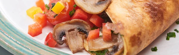 Primer plano de tortilla envuelta con setas y pimientos en el plato - foto de stock