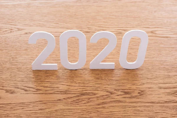 Papel blanco 2020 números sobre fondo marrón de madera - foto de stock