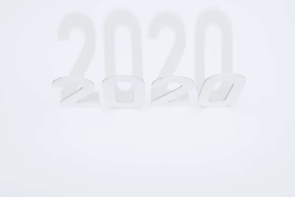 Vista superior de los números de papel 2020 con sombra sobre fondo blanco - foto de stock