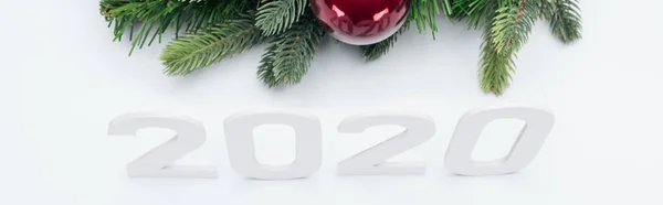 Top view of paper 2020 numbers near Christmas tree wreath with bauble on white background, panoramic shot — Stock Photo