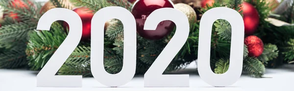 Papel 2020 números cerca de la corona del árbol de Navidad con adornos sobre fondo blanco, tiro panorámico - foto de stock