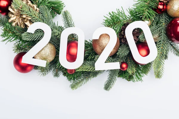 Vue du dessus des numéros 2020 sur la couronne de sapin de Noël sur fond blanc — Photo de stock