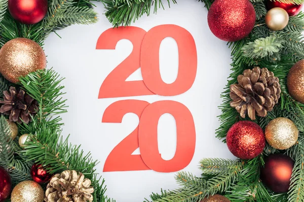 Vista superior de los números de papel 2020 en la corona del árbol de Navidad sobre fondo blanco - foto de stock