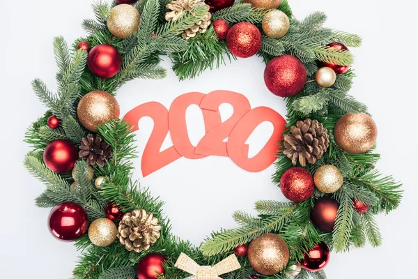 Vista superior de los números de papel 2020 en la corona del árbol de Navidad sobre fondo blanco - foto de stock