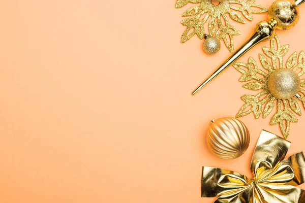 Top view of golden Christmas decoration on orange background with copy space — Stock Photo