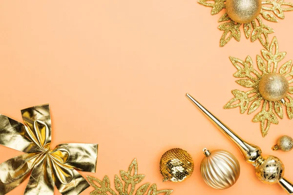 Top view of golden Christmas decoration on orange background with copy space — Stock Photo