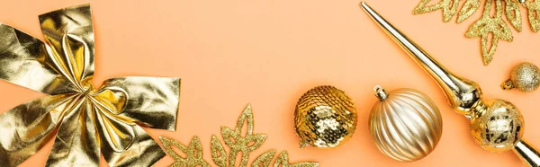 Top view of golden Christmas decoration on orange background, panoramic shot — Stock Photo