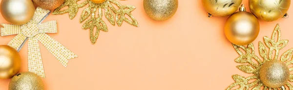 Top view of golden Christmas decoration on orange background with copy space, panoramic shot — Stock Photo